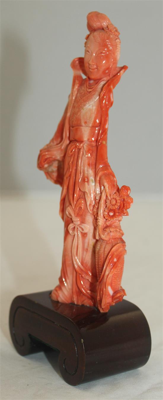 A Chinese coral figure of a beautiful lady holding a basket of flowers, 17.5cm incl. wood stand